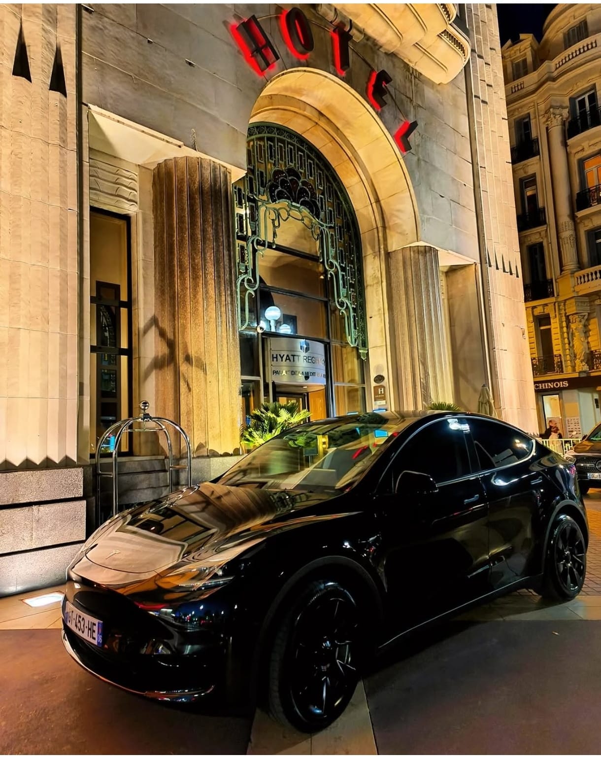 Voiture noire stationnée devant l’entrée d’un hôtel de nuit